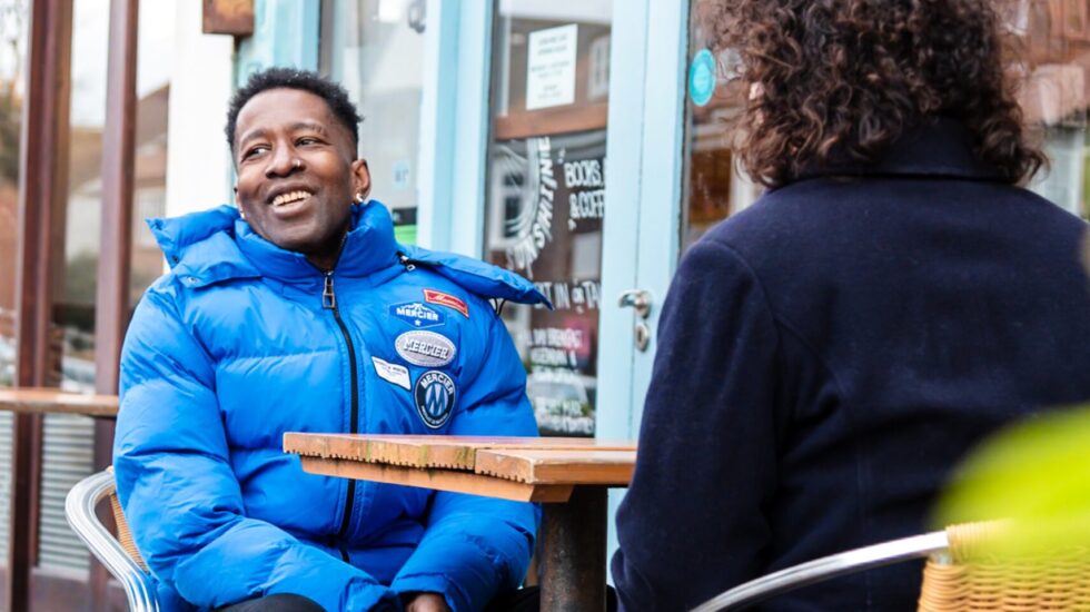 A Southdown tenant and employee are sitting outside a cafe and are chatting.