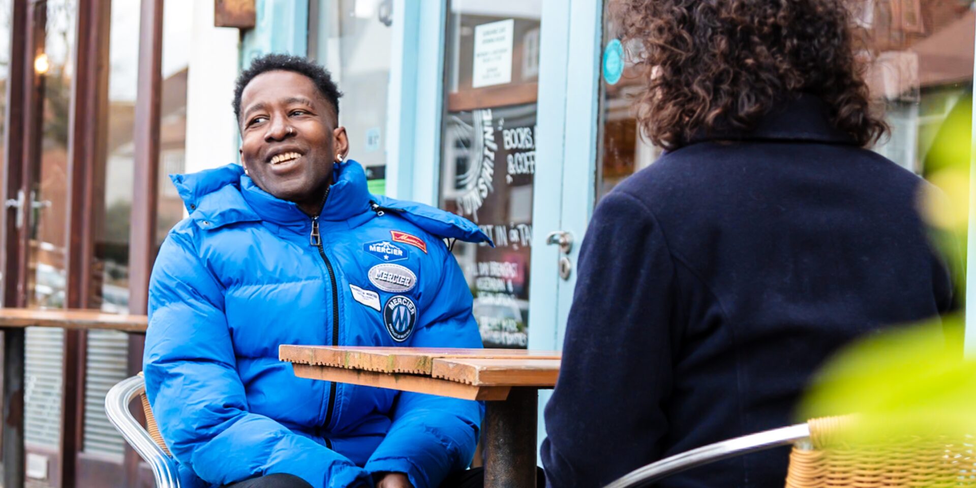 A Southdown tenant and employee are sitting outside a cafe and are chatting.